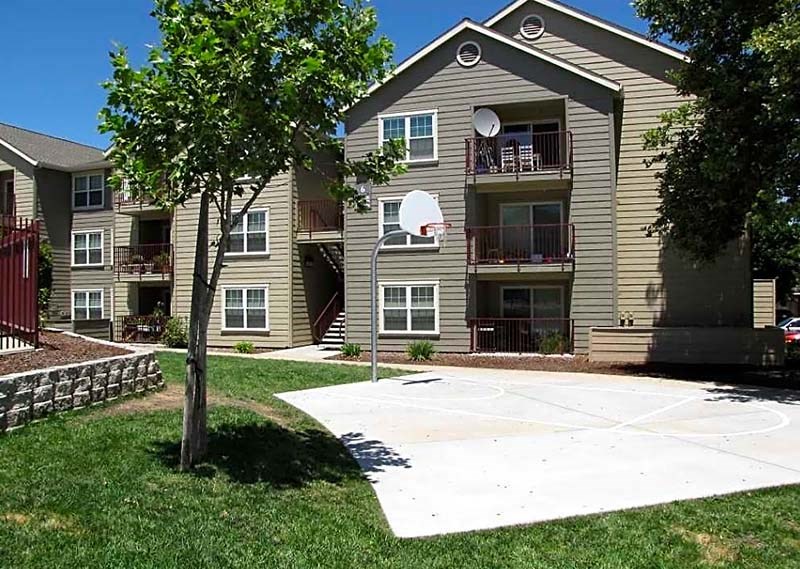 Basketball court near buildings and grass
